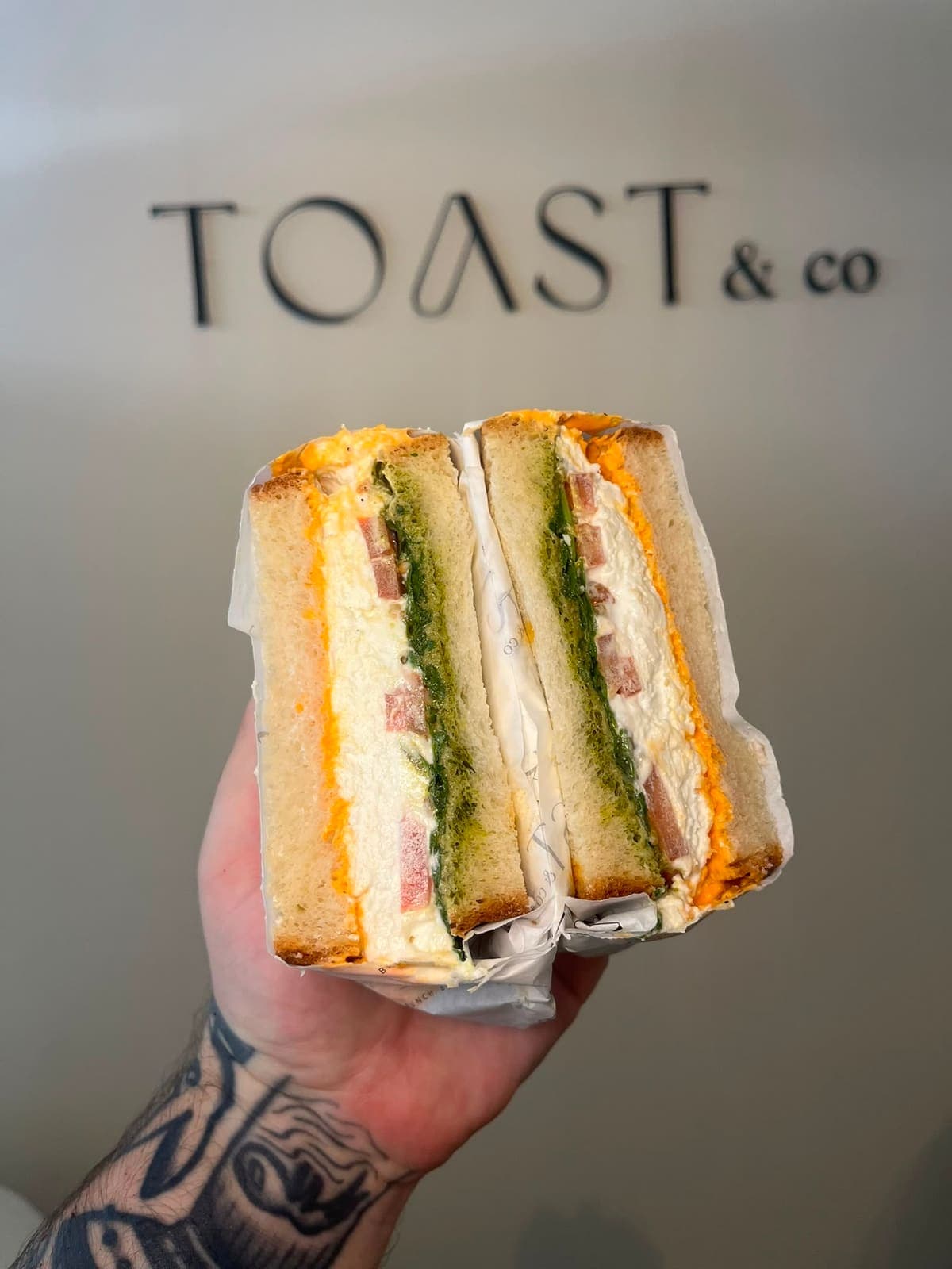 Farmhouse sandwich with whipped feta, balsamic beef tomato, basil pesto, romesco mayo and rocket